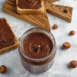 chocolate-spread-or-nougat-cream-with-hazelnuts-in-glass-jar-on